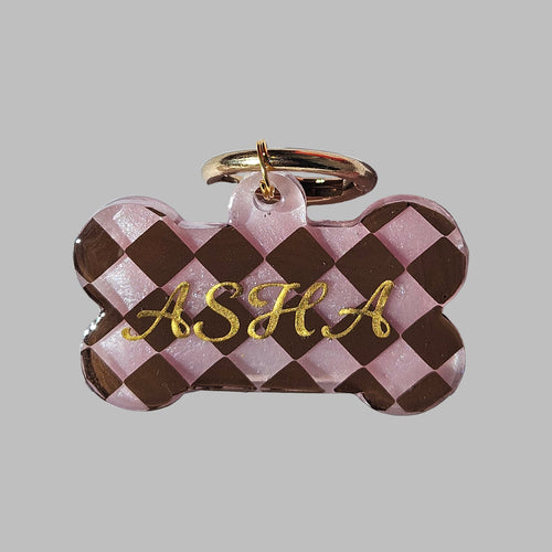 Checkered bone-shaped keychain with gold text on a light blue background